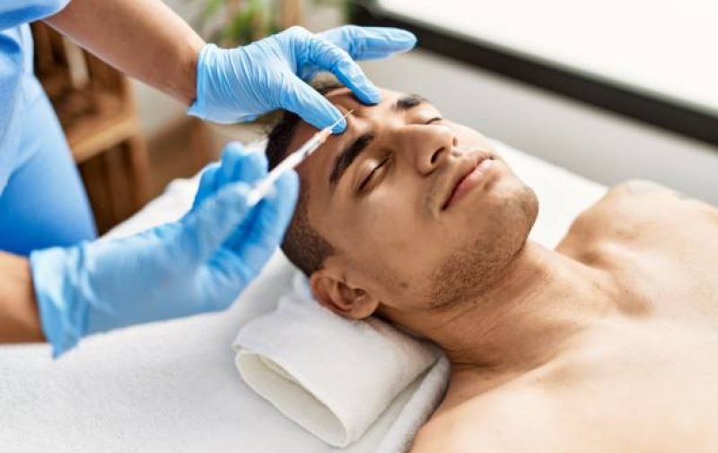 Doctor injecting botox on man face for anti aging treatment at the clinic.